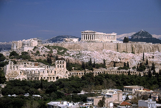 View of the Acropolis and the South Slope from the southwest (from near the Philopappos Monument). - In the background to the right of the Parthenon are Mt. Lykabettos and Mt. Penteli. Photo taken in 1998. by Kevin T. Glowacki and Nancy L. Klein