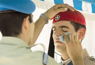 A soldier wipes the face of an evzone, who is not allowed to move as long as he remains on guard, outside Parliament in central Athens, yesterday. The temperature rose to around 40C (104F) yesterday in a heat wave that is expected to continue over the next few days. The City of Athens and the Athens-Piraeus Prefecture have opened doors to many of their air-conditioned facilities to locals looking for a place to cool off. More information is available on 1539. The National Meteorological Service (EMY) said there will be little relief from the heat before Wednesday.